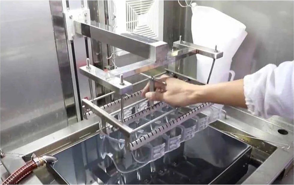 Coating line loading. Lens carriers are loaded by hand into the treatment tanks.